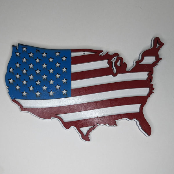 Wood engraved wall art in the shape of the United States with American flag design on a white background.