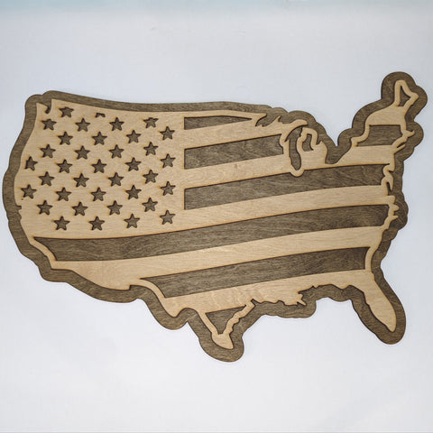Wooden cutout of the United States in the shape of the American flag on a white background